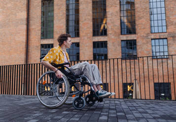 Gen Z boy in a wheelchair in the city. Inclusion, equality, and diversity among Generation Z. - HPIF33905