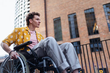 Gen Z boy in a wheelchair in the city. Inclusion, equality, and diversity among Generation Z. - HPIF33906