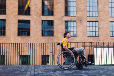 Gen Z boy in a wheelchair in the city. Inclusion, equality, and diversity among Generation Z. - HPIF33907