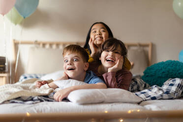 Happy children lying in the bed and having fun together. - HPIF33933