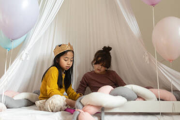 Happy girls playing princess in indoor play tent. - HPIF33942