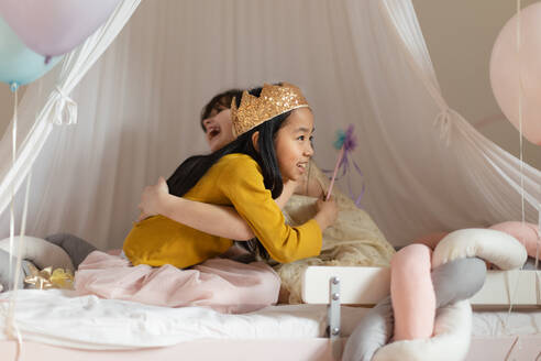 Happy girls playing on princess in room. - HPIF33946