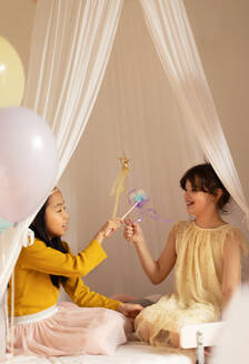 Happy girls playing on princess in room. - HPIF33947