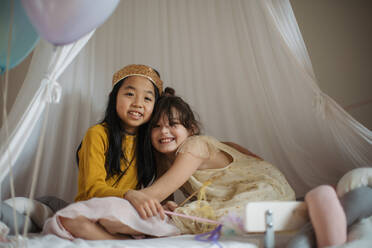 Happy girls playing on princess in room. - HPIF33948