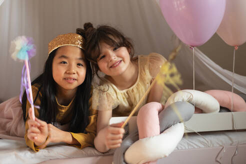 Happy girls playing on princess in room. - HPIF33950