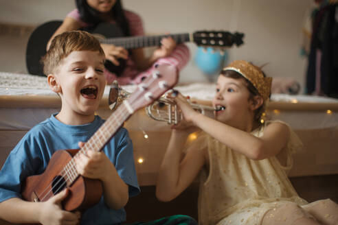 Happy three friends playing on the musical instuments. - HPIF33959