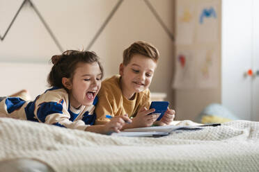 Sister and brother learing together. Happy friends having fun and do the math homework together. - HPIF33991