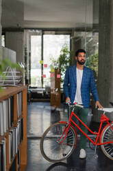 Young multiracial man with bicyckle in an office. - HPIF34006