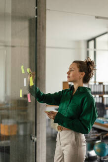 Young woman taking notes in the office. Brainstorming, mind mapping techniques. - HPIF34058