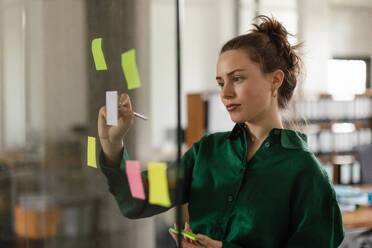 Young woman taking notes in the office. - HPIF34059