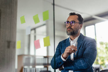 Businessman in suit taking notes in the office. Brainstorming, mind mapping techniques. - HPIF34075