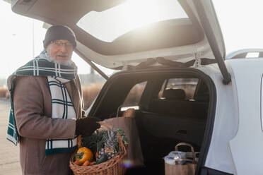 Close-up of somebody giving his purchase in the electric car trunk. - HPIF34136