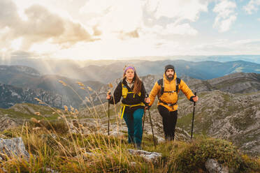 Two hikers hiking in the mountains. couple of mountaineers ascending a mountain. sport and physical activity in nature. - ADSF50220