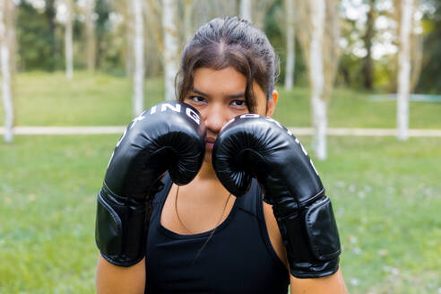 Hispanic weiblichen Boxer Porträt Training mit Boxhandschuhen in einer Wache Position. Fighting Sport im Freien Training. - ADSF50235