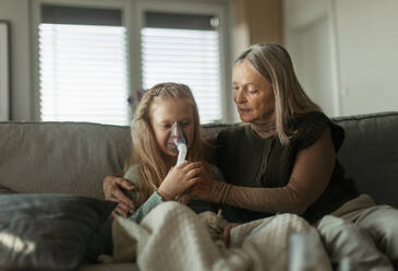Eine ältere Frau kümmert sich um ihre kranke Enkelin. - HPIF34176