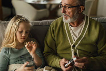 Ein älterer Mann kümmert sich um seine kranke Enkelin. - HPIF34188