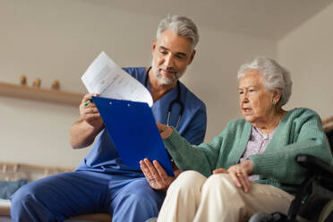 Caregiver doing regular check-up of senior client in her home. - HPIF34305