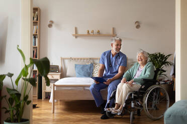 Pflegekraft bei der regelmäßigen Kontrolle einer älteren Kundin in ihrem Haus. - HPIF34306