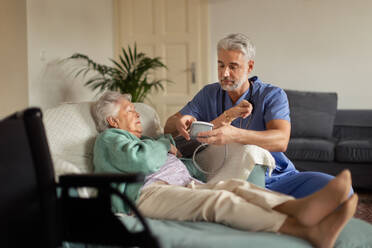 Caregiver doing regular check-up of senior client in her home. - HPIF34307
