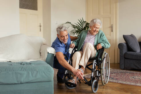 Caregiver doing regular check-up of senior client in her home. - HPIF34312