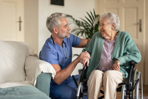 Caregiver doing regular check-up of senior client in her home. - HPIF34313