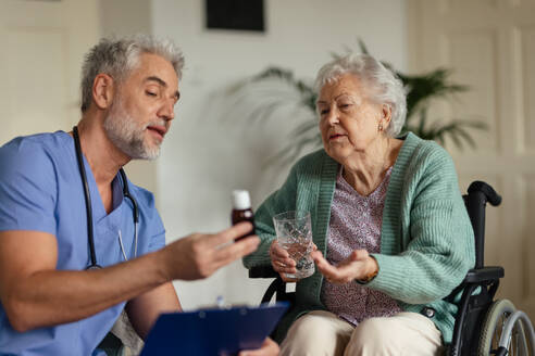 Caregiver doing regular check-up of senior client in her home. - HPIF34315
