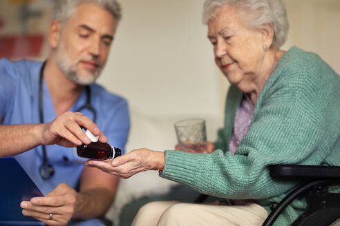 Caregiver doing regular check-up of senior client in her home. - HPIF34317