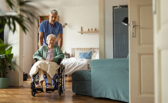 Caregiver doing regular check-up of senior client in her home. - HPIF34323