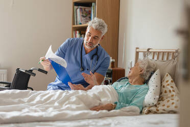 Pflegekraft bei der regelmäßigen Kontrolle einer älteren Kundin in ihrem Haus. - HPIF34325
