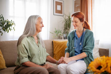 Porträt eines Pflegers, der einem älteren Kunden die Hand hält. - HPIF34367