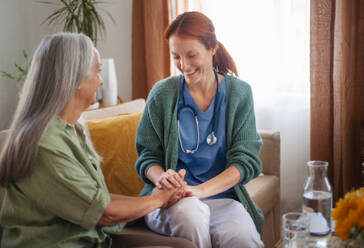 Porträt eines Pflegers, der einem älteren Kunden die Hand hält. - HPIF34370
