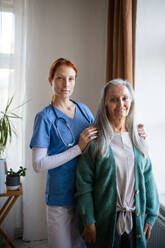 Portrait of senior caregiver and senior woman in her home. - HPIF34419