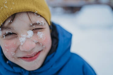 Smiling boy with snow on face - ANAF02535