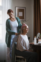 Nurse spending quality time with senior woman at her home, combing her beautiful hair. Mature woman taking care of her elderly mother. - HPIF34442