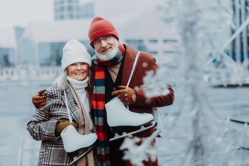 Porträt von Senioren im Winter auf einer Eislaufbahn im Freien. - HPIF34448