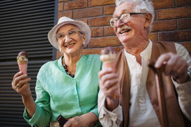 Portrait of senior friends in the city, eating ice cream on a hot summer day. Elderly ladies on summer vacation in the city. Pensioners on group trip. Concept of senior vacation and travel groups, clubs. - HPIF34539