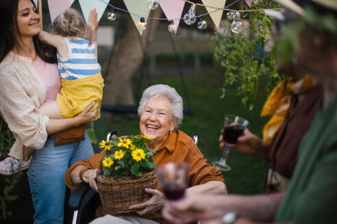 Familie feiert Party an einem warmen Sommerabend im städtischen Garten. Mehrgenerationenfamilie feiert Geburtstag und feiert Gartenparty im Hinterhof. - HPIF34590