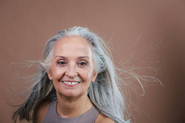 Portrait of smiling senior woman in a studio. - HPIF34613