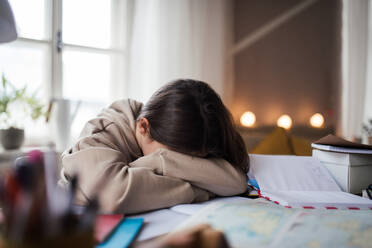 Unhappy girl doing a homework in her room. - HPIF34775