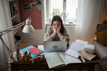 Junges Mädchen im Teenageralter, das in ihrem Zimmer lernt und Hausaufgaben macht. - HPIF34786