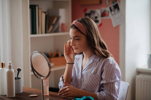 Teenager-Mädchen bei ihrer Hautpflege im Zimmer. - HPIF34795
