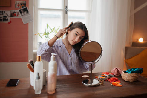 Teenager-Mädchen macht ihre Hautpflege-Routine und Frisur im Zimmer. - HPIF34799