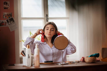 Teenager-Mädchen macht ihre Hautpflege-Routine und macht sich bereit, bevor sie in ihrem Zimmer ausgeht. - HPIF34802