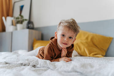 Porträt eines kleinen Jungen, der im Bett liegt. - HPIF34927