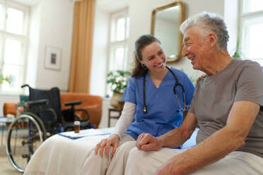 Junge Krankenschwester kümmert sich um einen älteren Menschen in seinem Haus. - HPIF35013