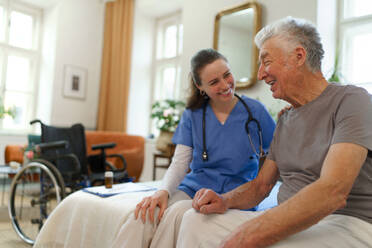 Young nurse taking care of elderly senior in his home. - HPIF35013