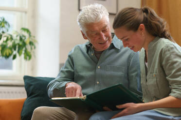 Senior man with his grandaughter reading book. - HPIF35045