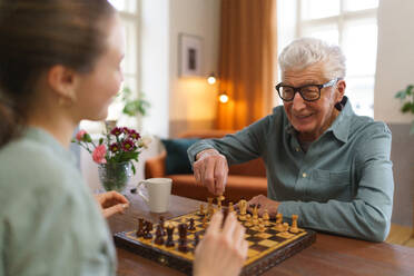 Älterer Mann spielt Schach mit seiner Betreuerin. - HPIF35050