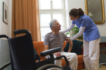Junge Krankenschwester kümmert sich um einen älteren Menschen und hilft ihm beim Gehen. - HPIF35065
