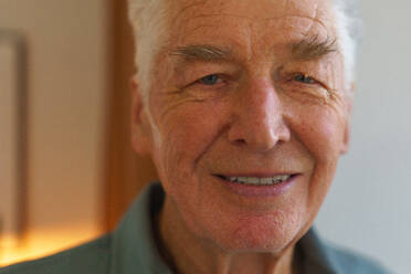 Porträt eines lächelnden älteren Mannes in seinem Haus. - HPIF35096